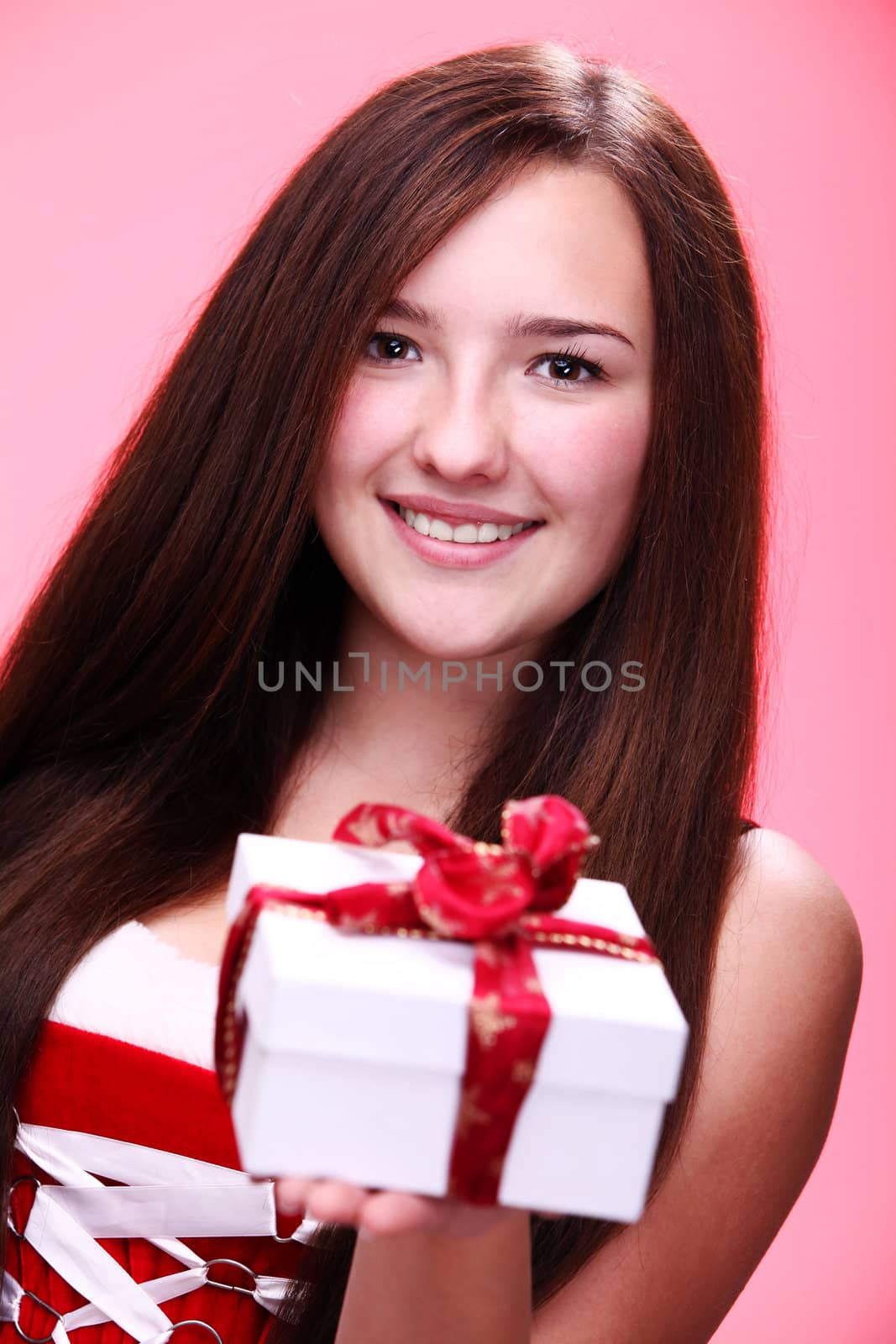 Portrait of young and beautiful christmas girl in red with gift