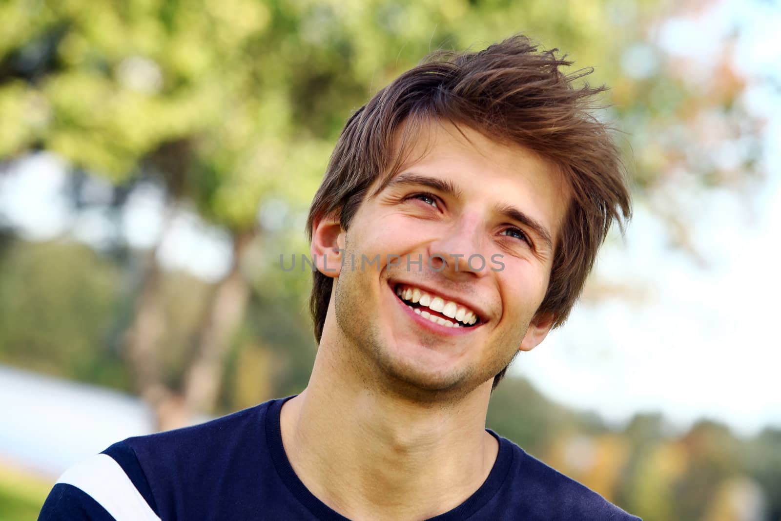 Portrait of young and smiling cute man in park