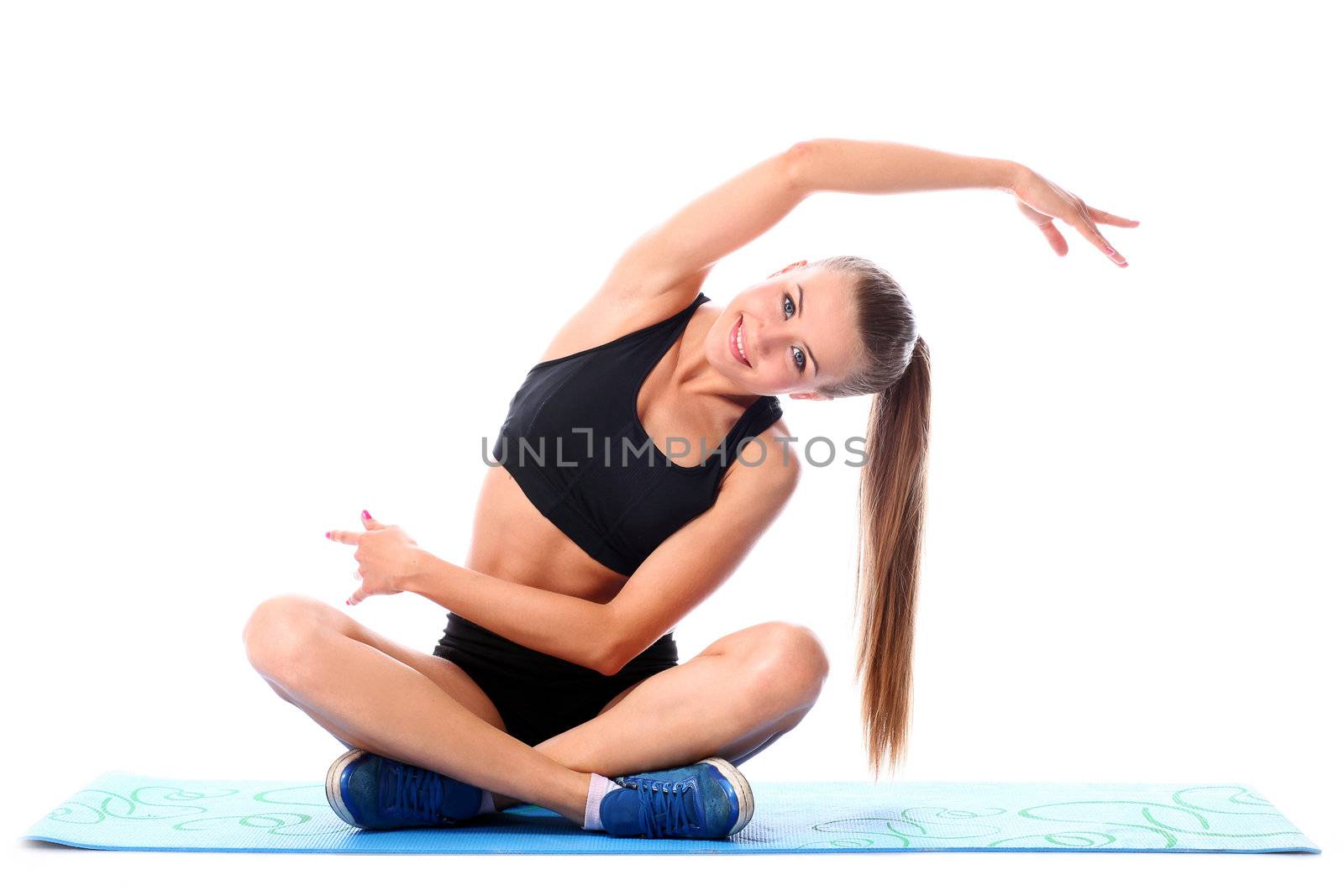 Happy girl doing fitness exercises on a mat over white background