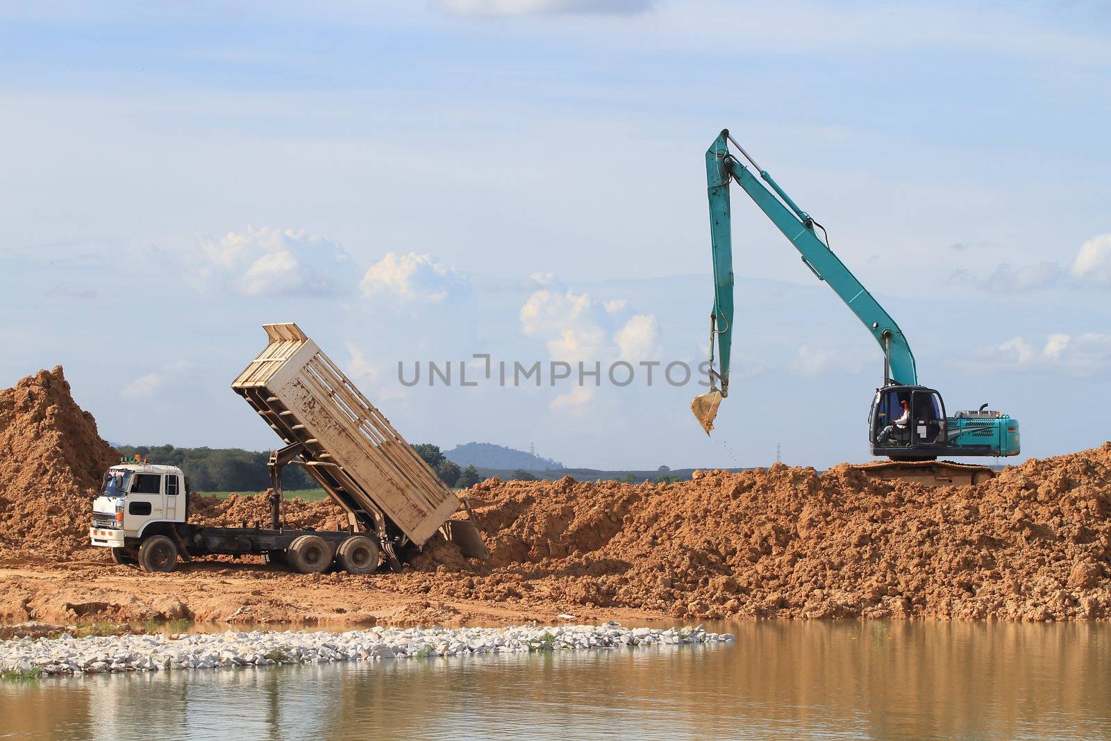 Excavator located by a river and ready for work