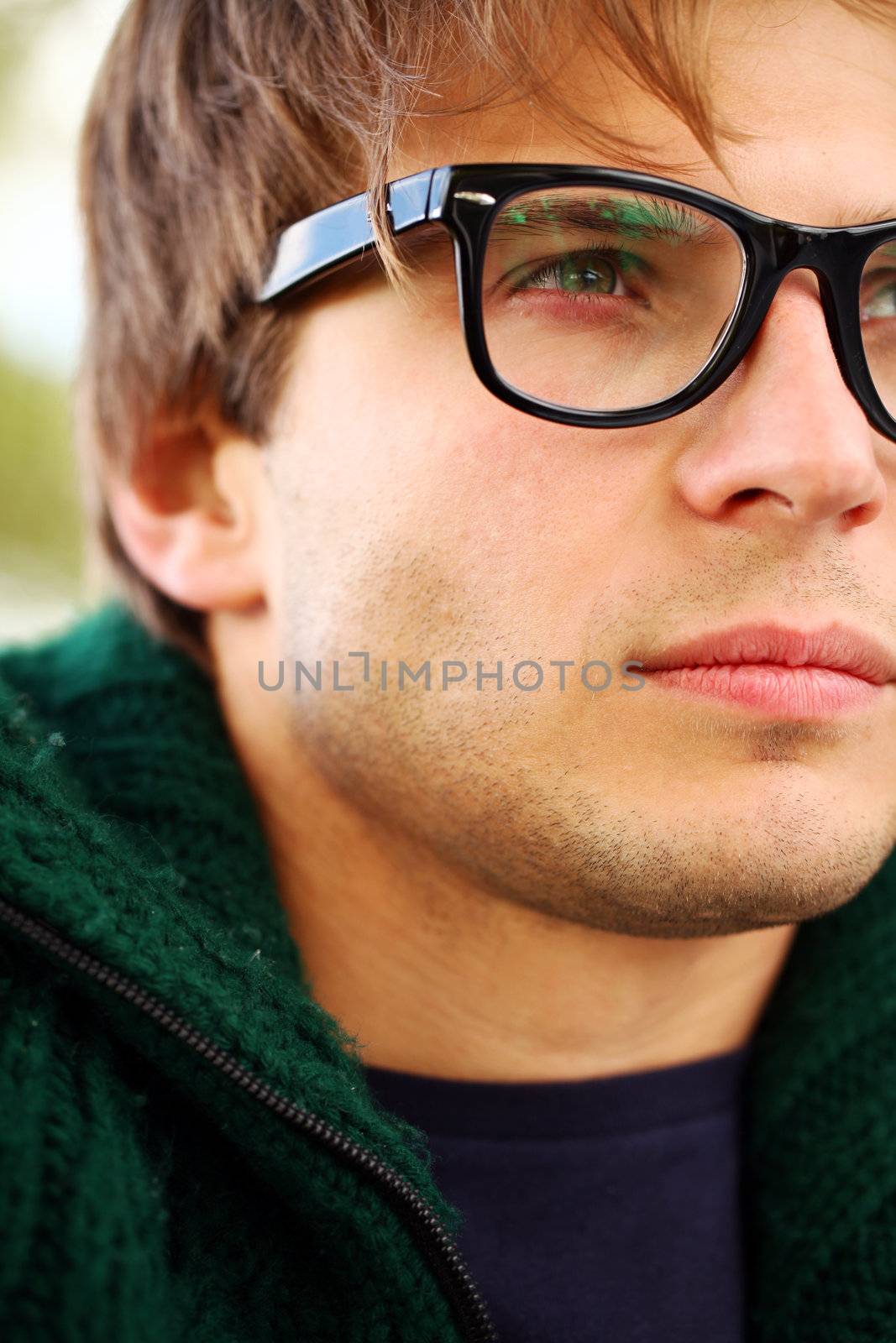 Potrait of handsome and smart guy at cold autumn day in the park