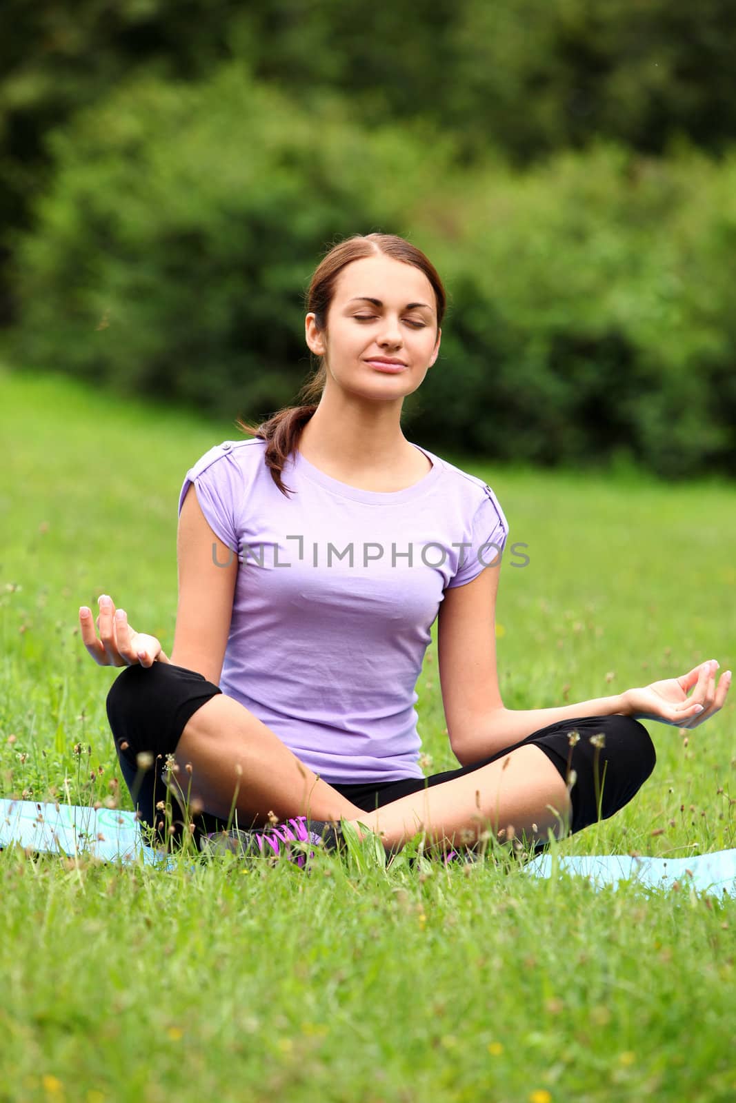 Beautiful woman doing yoga workout in the park by rufatjumali