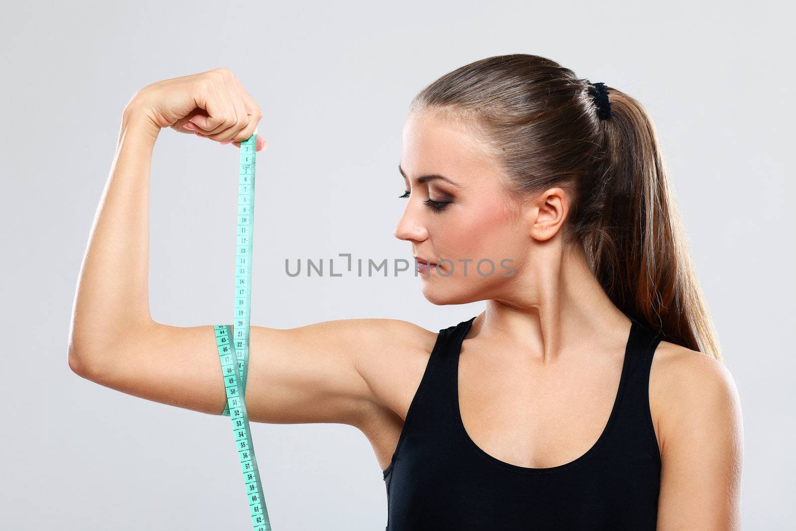 Beautiful girl measure her biceps with a  ruler by rufatjumali