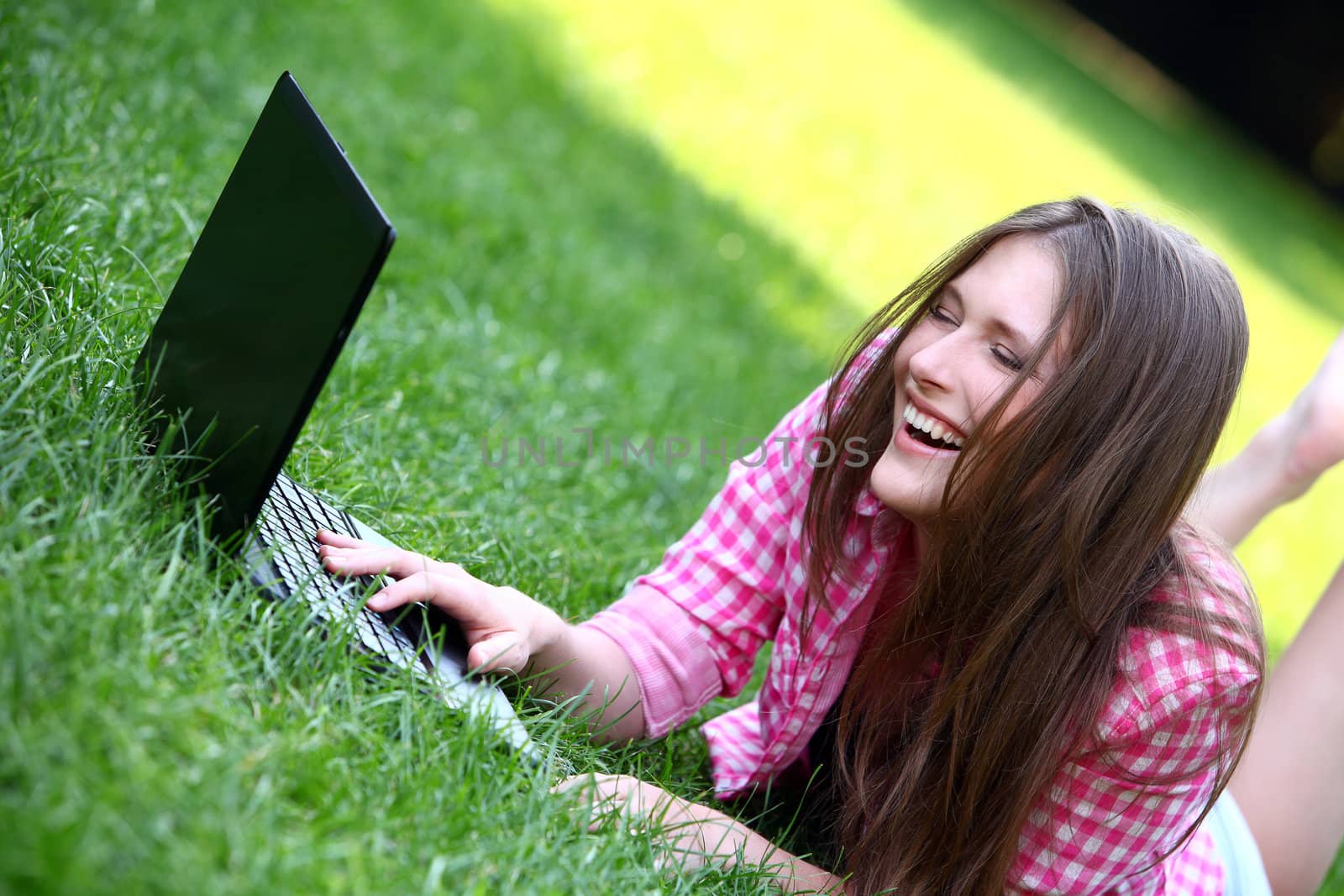 Beautiful woman with laptop in park by rufatjumali