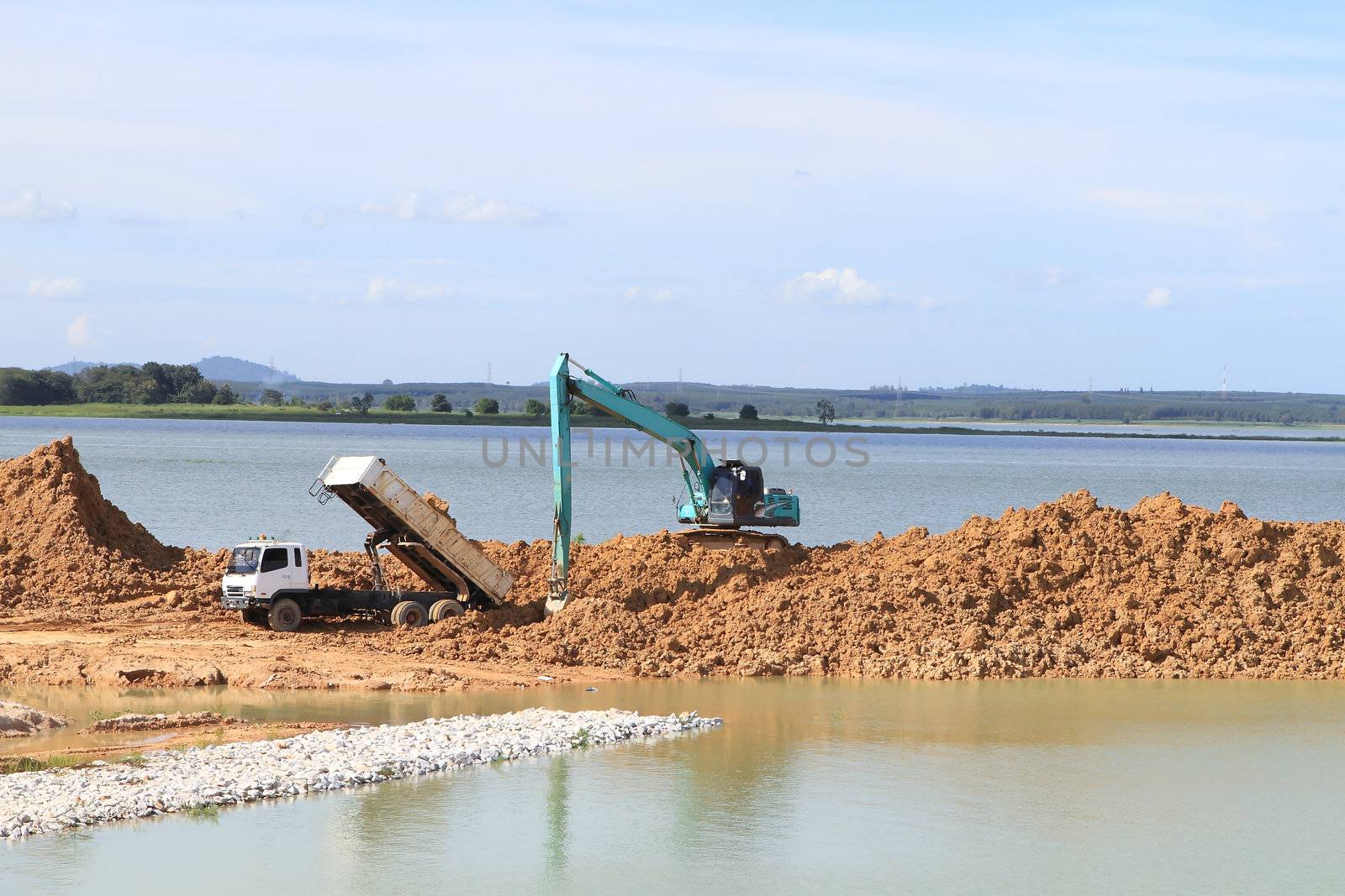 Excavator located by a river and ready for work