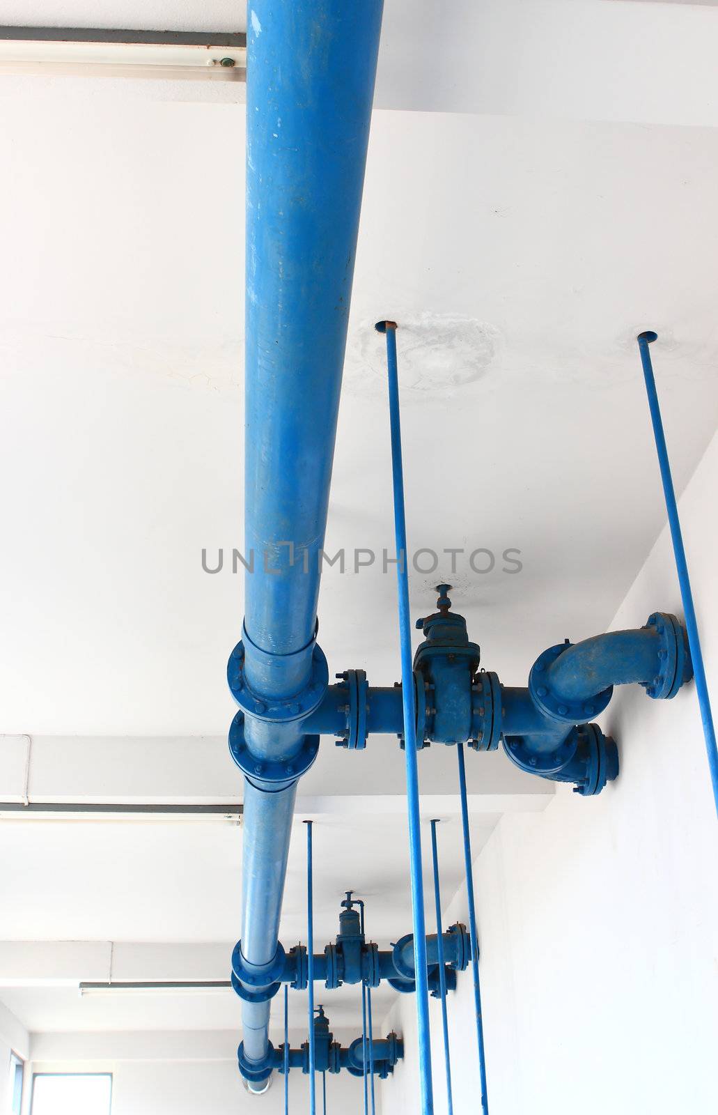 blue pipe line with blue valve on  wall