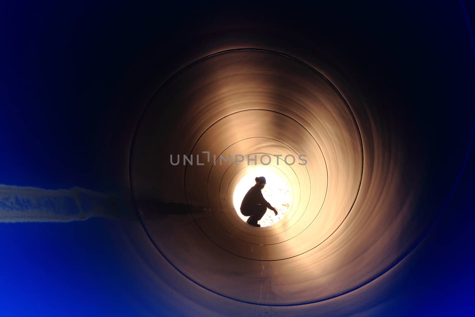 A silhouette of a worker in pipe