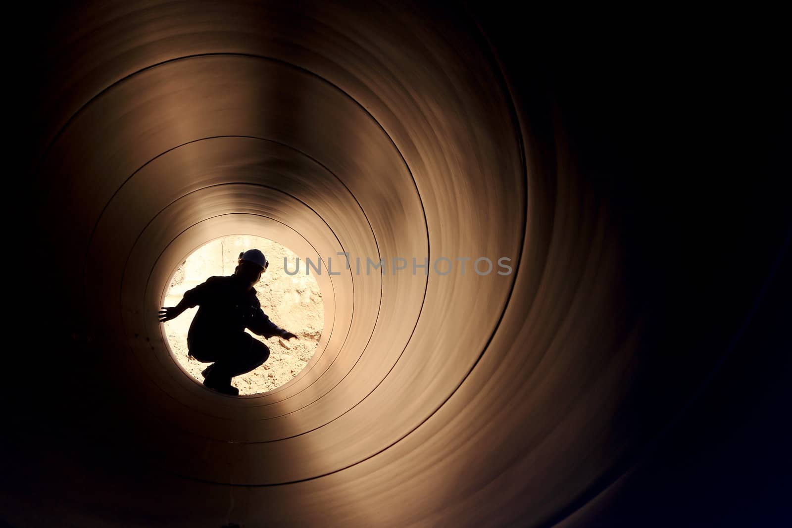 A silhouette of a worker in pipe