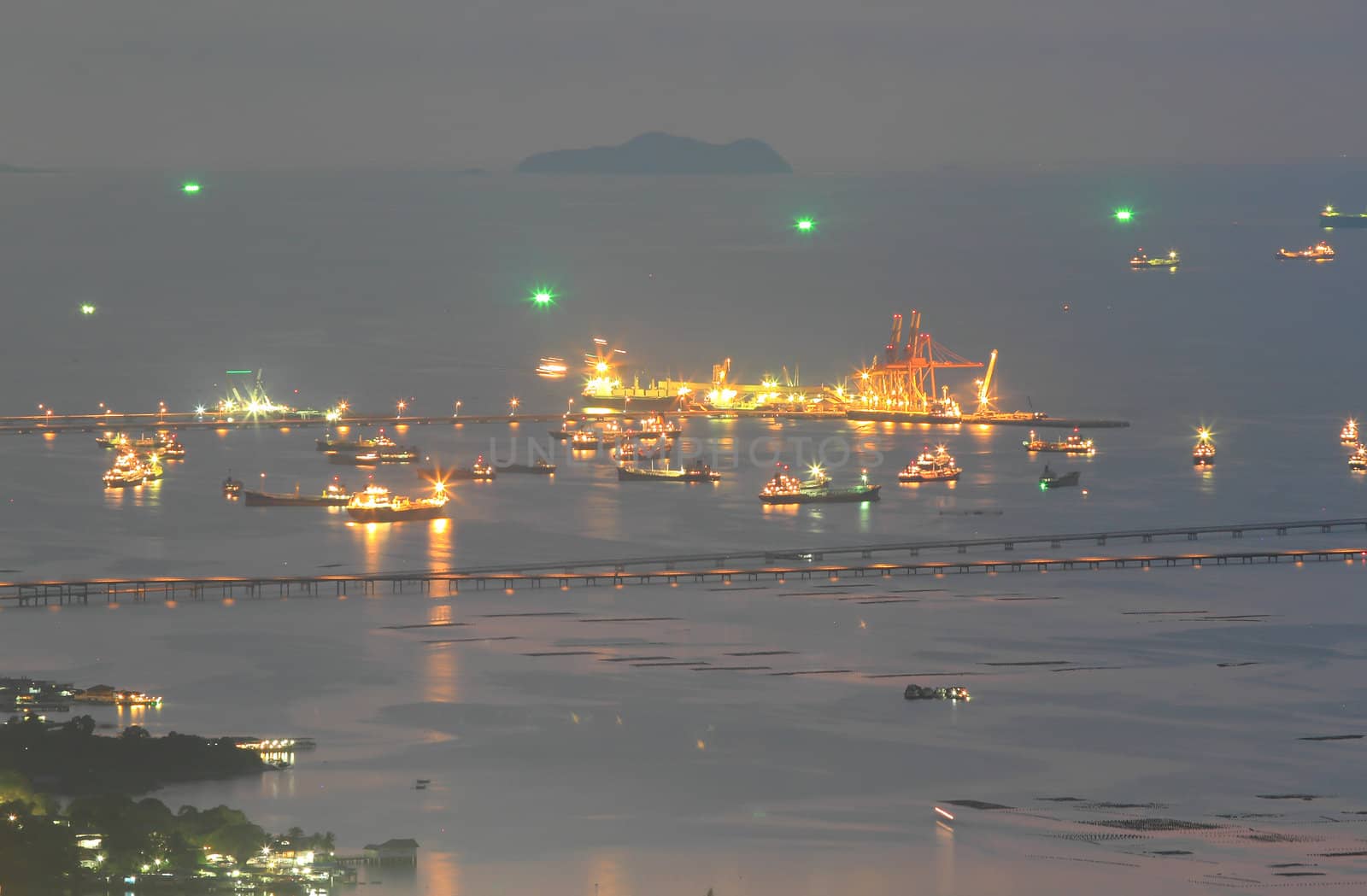 Port warehouse with cargoes and containers at night by rufous