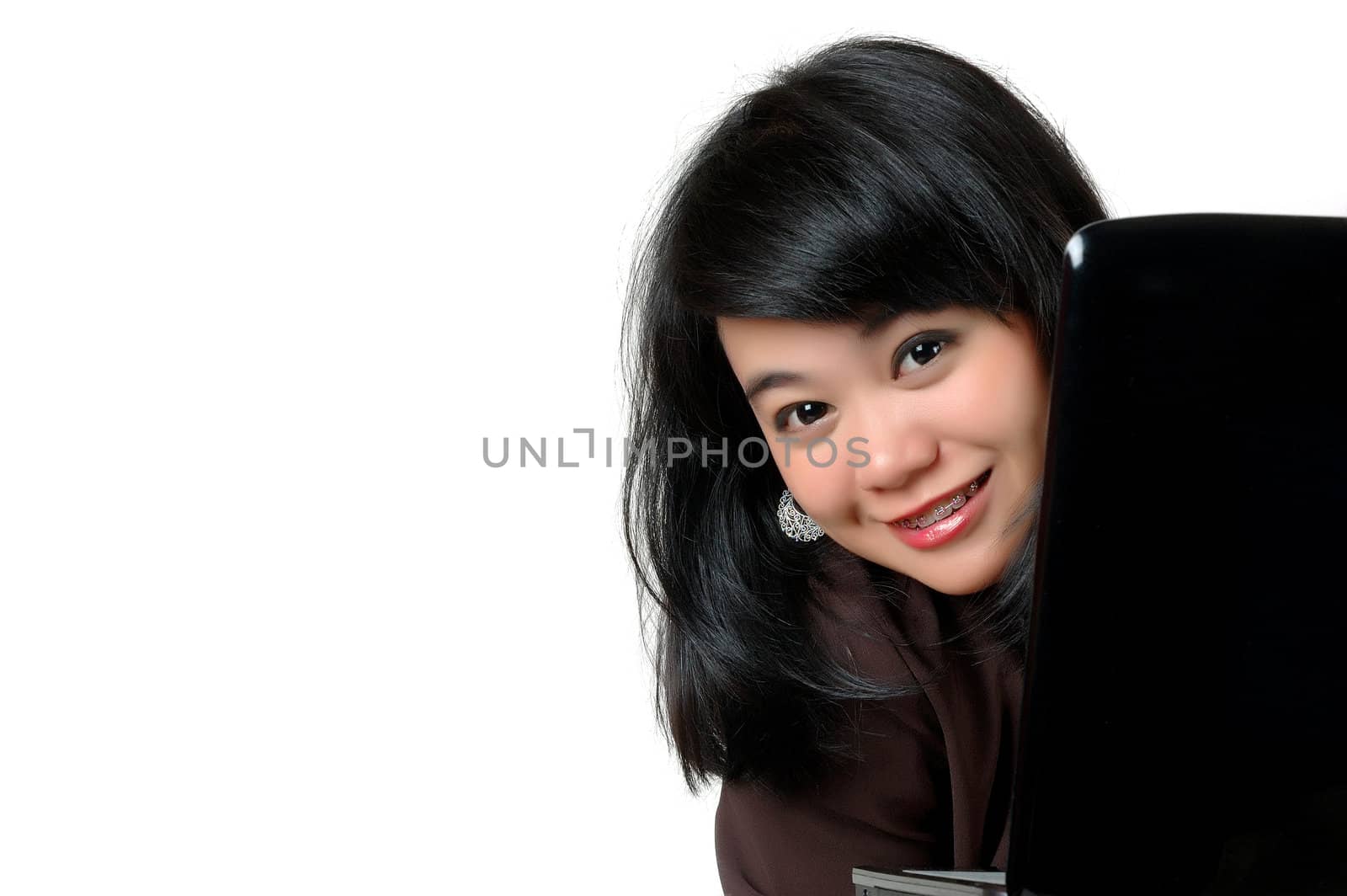 asian young businesswoman peered from behind the laptop isolated on white