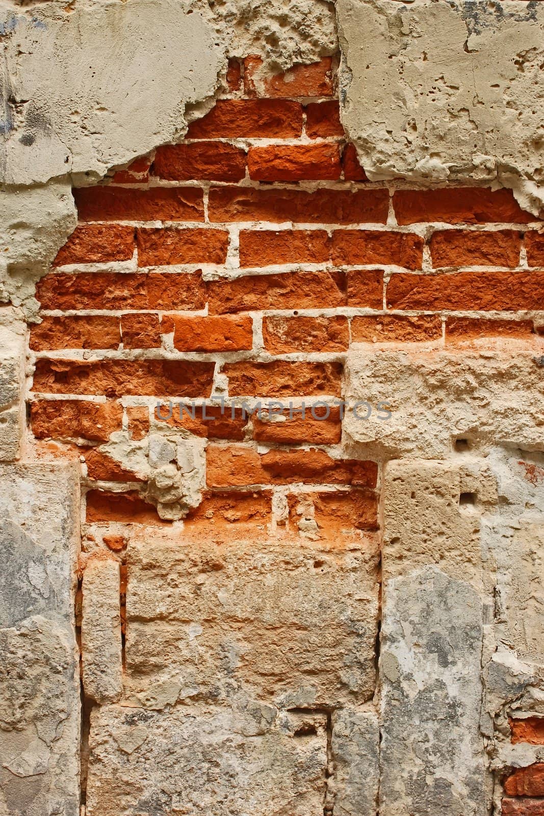 Fragment of old brick masonry on a foundation with destroyed stucco close-up