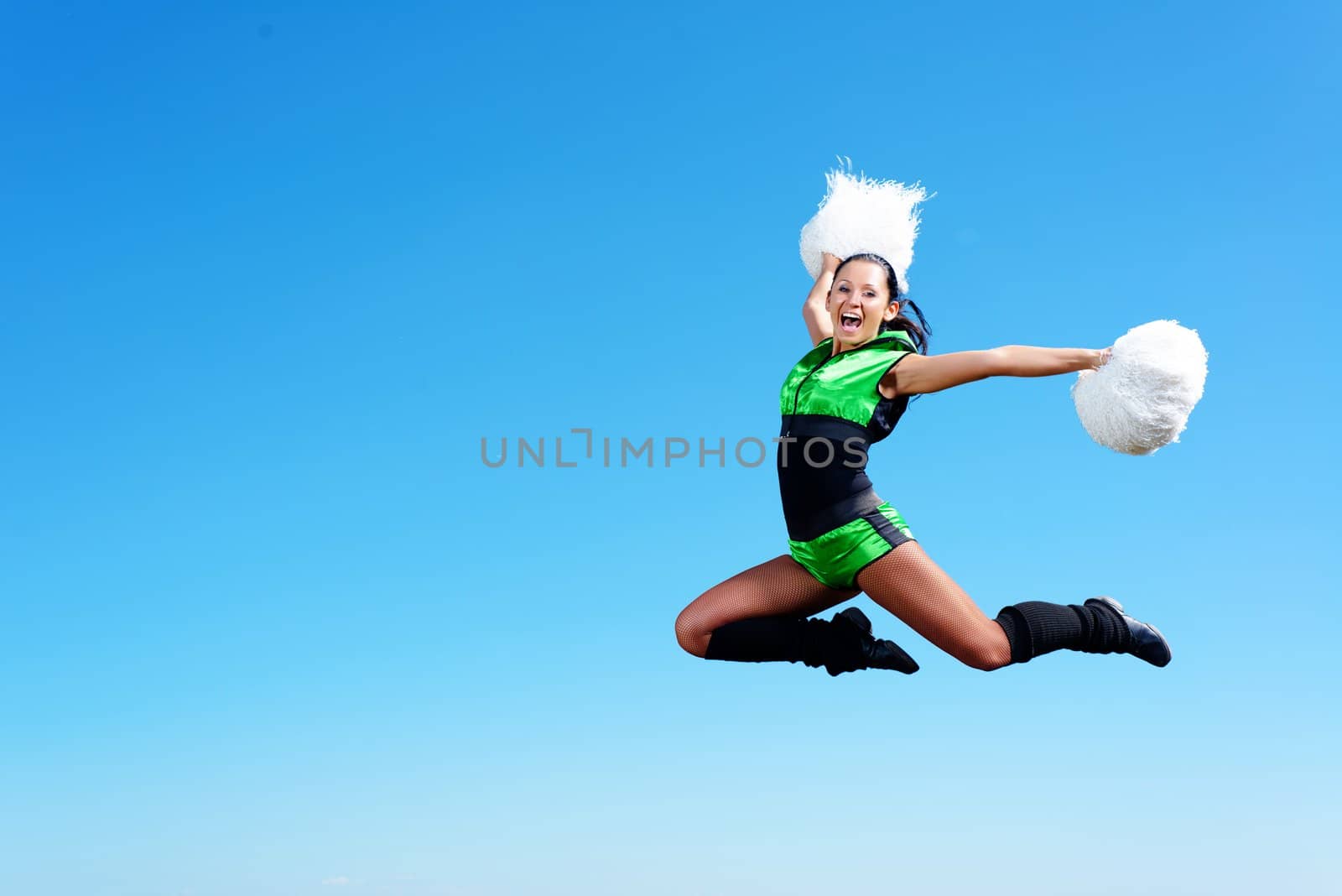 cheerleader girl jumping on a background of blue sky