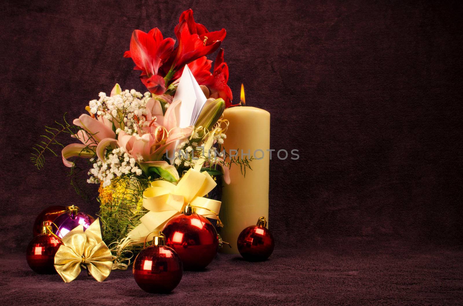 Christmas baubles with flower and candle on red background