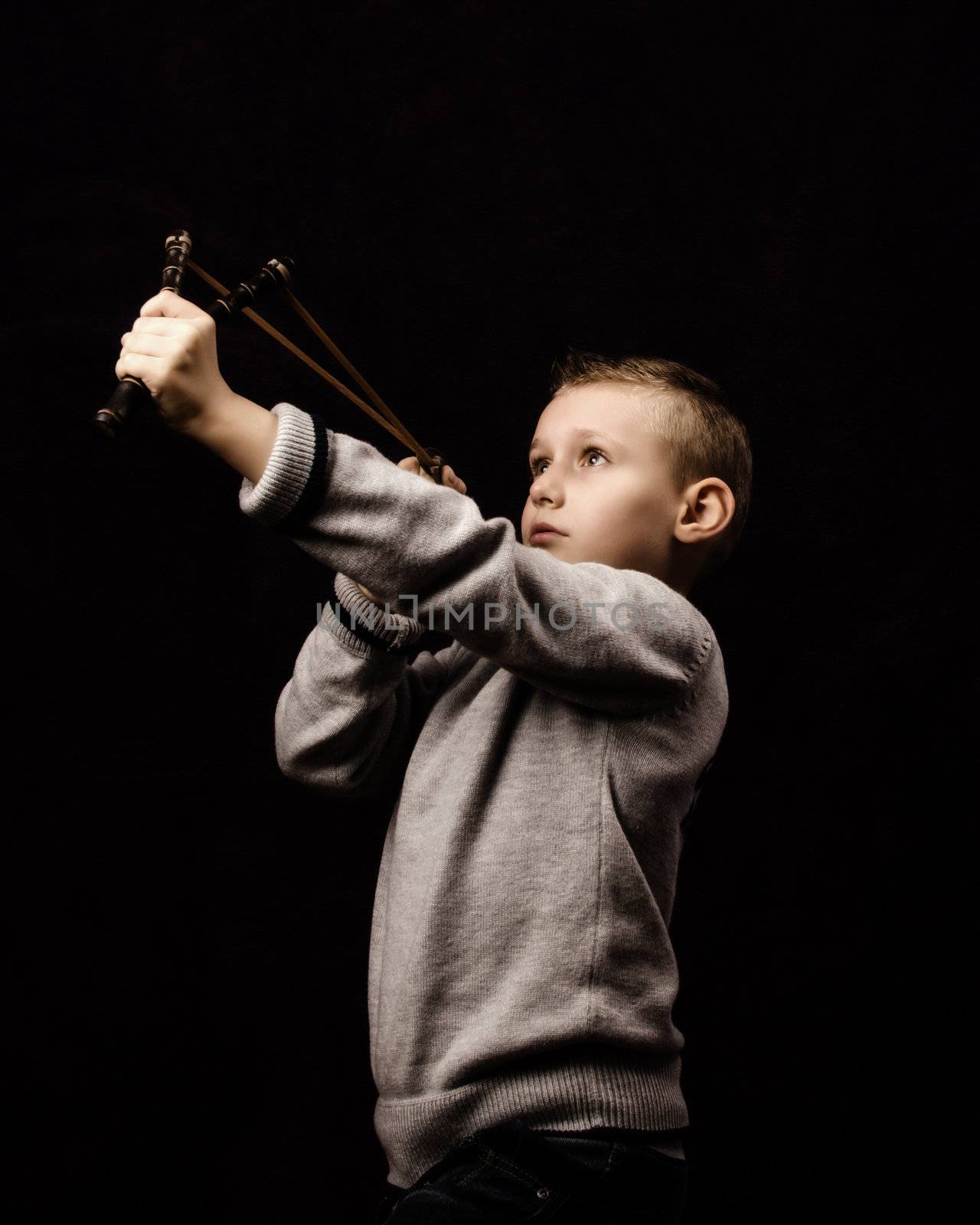 Little boy shooting with a slingshot