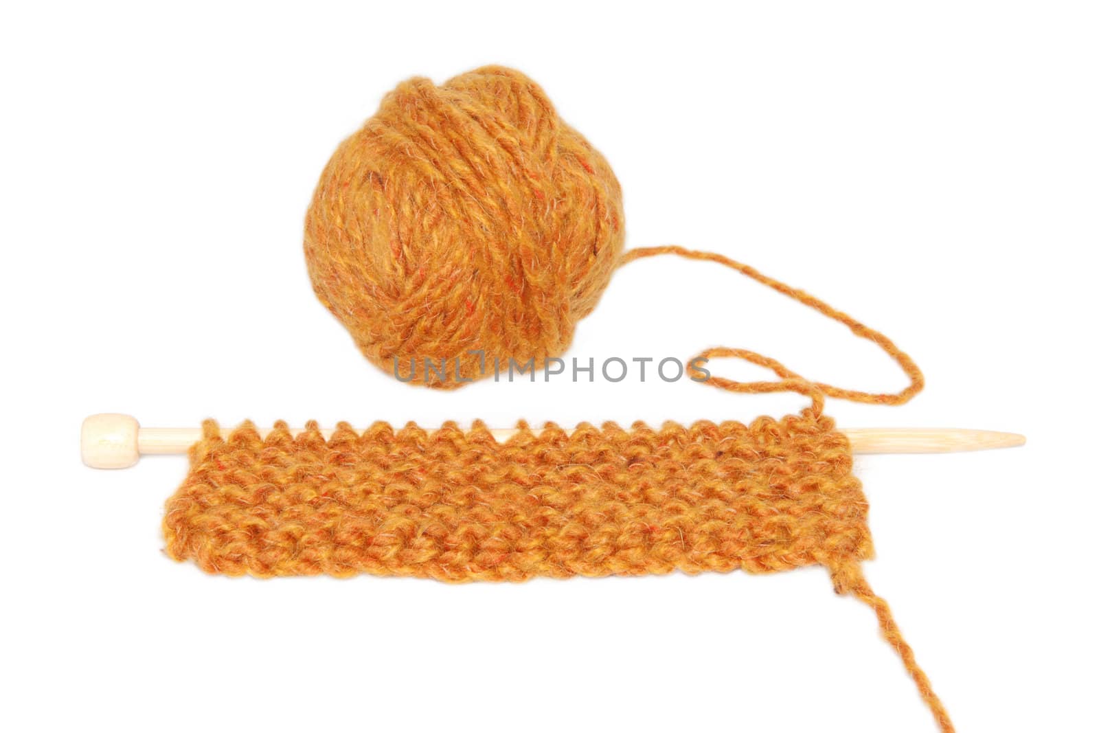 Knitting in garter stitch on one needle with a ball of wool, isolated on a white background