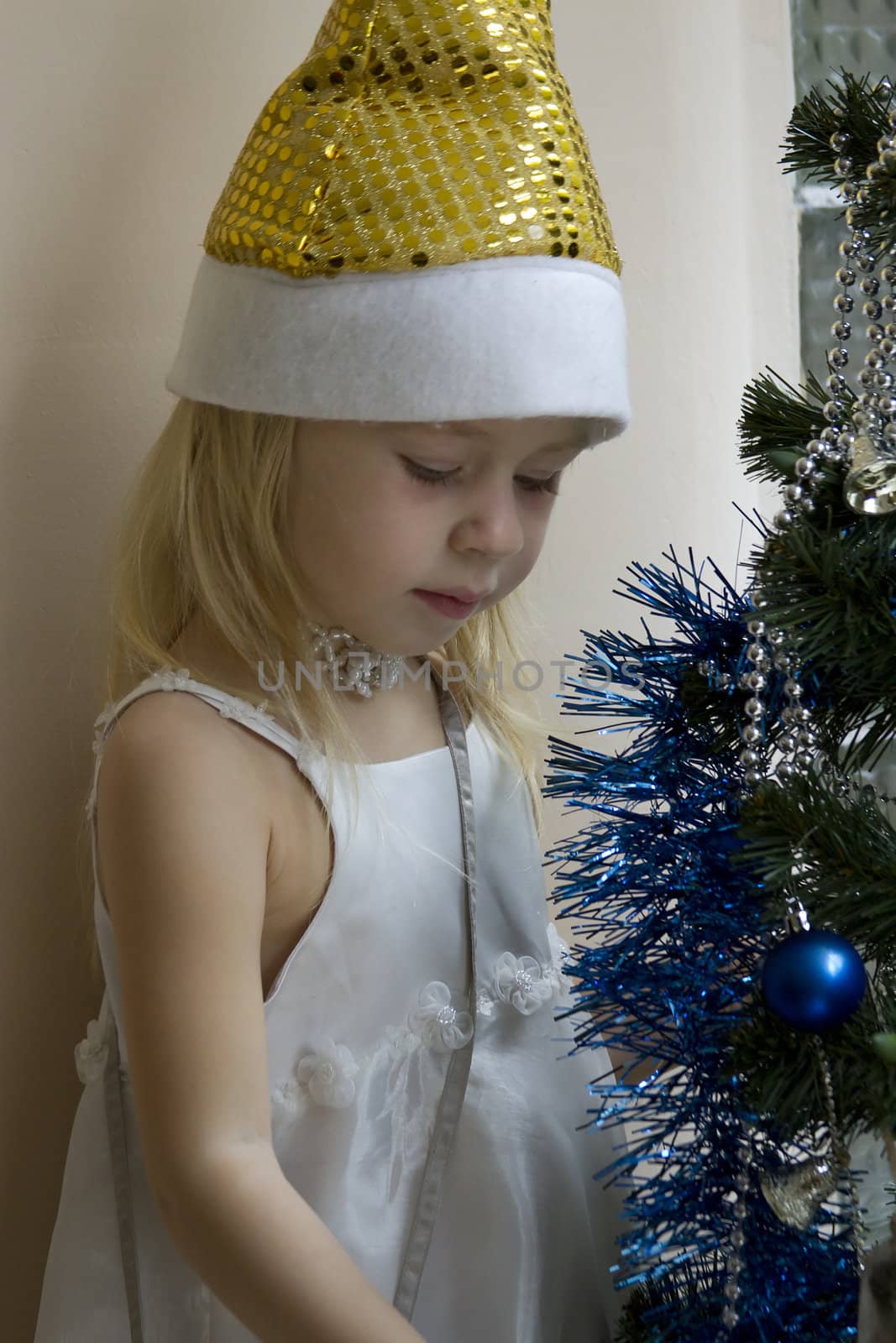 Portrait of happy girl in Santa cap  Christmas tree