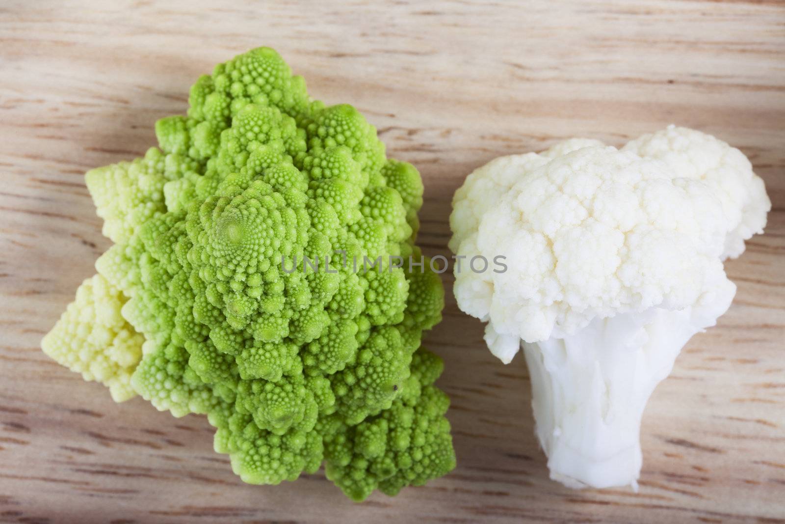 Fresh cauliflower and romanesco broccoli on board