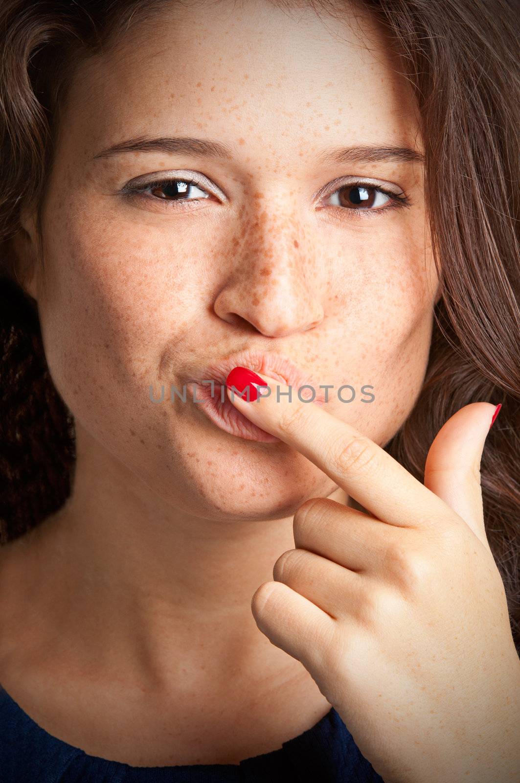 Closeup of a young female with her finger in her mouth