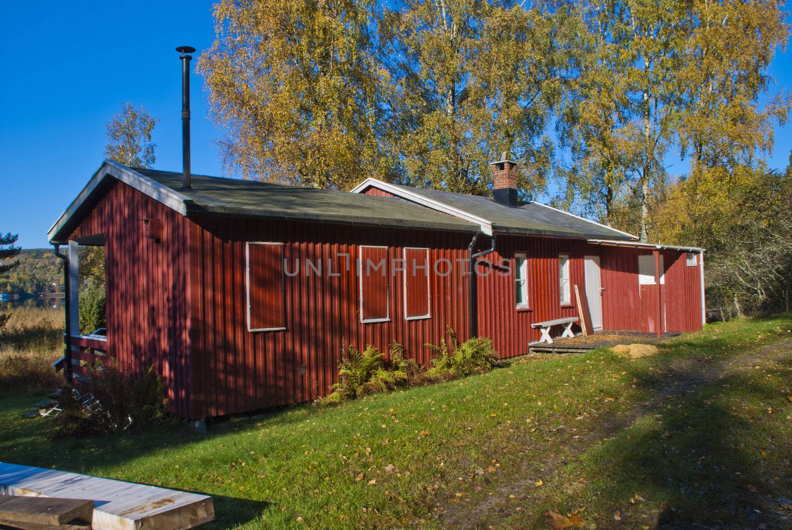 a cozy little red cabin situated close to the  iddefjord at bakke in halden municipality, the cabin has its own small beach 20 meters from the cabin wall, picture is shot in october 2012