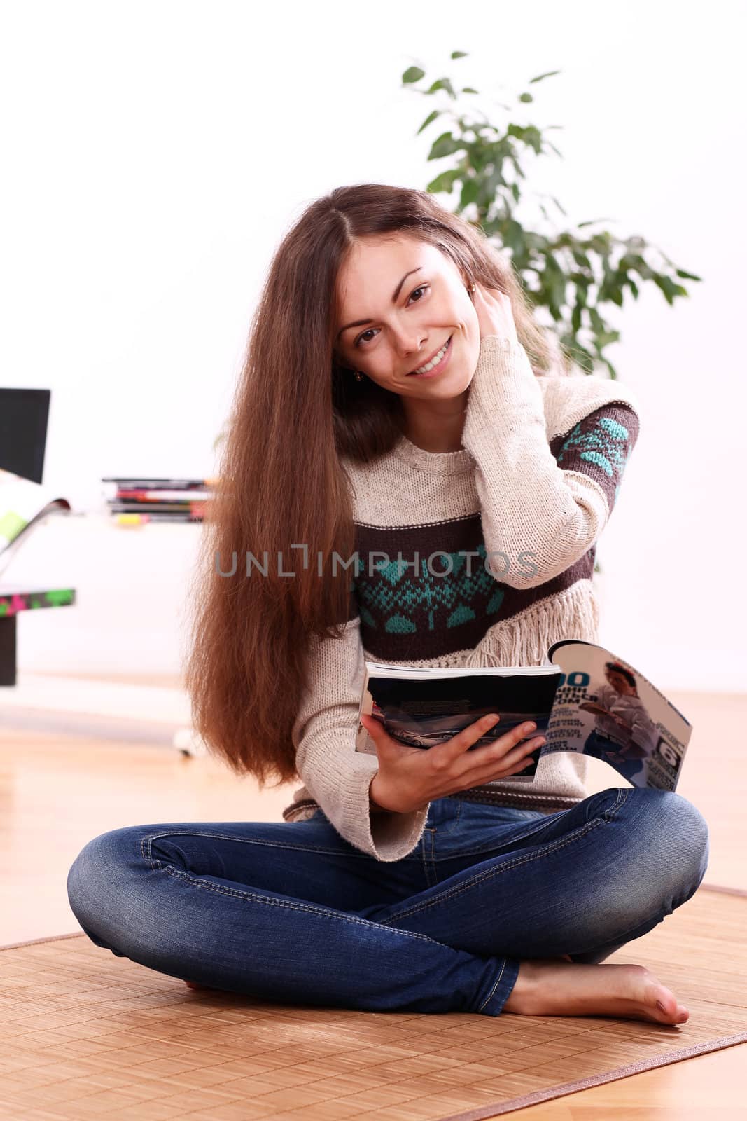 Close up of cute young woman reading magazine at home