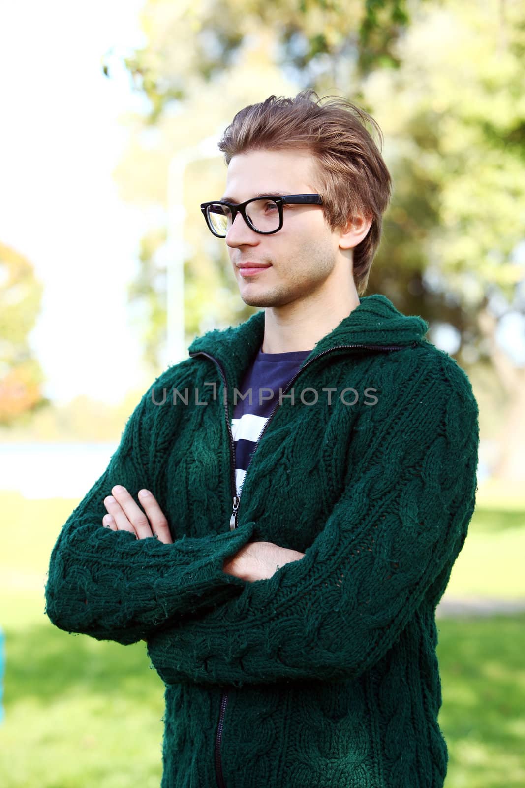 Potrait of handsome and smart guy at cold autumn day in the park