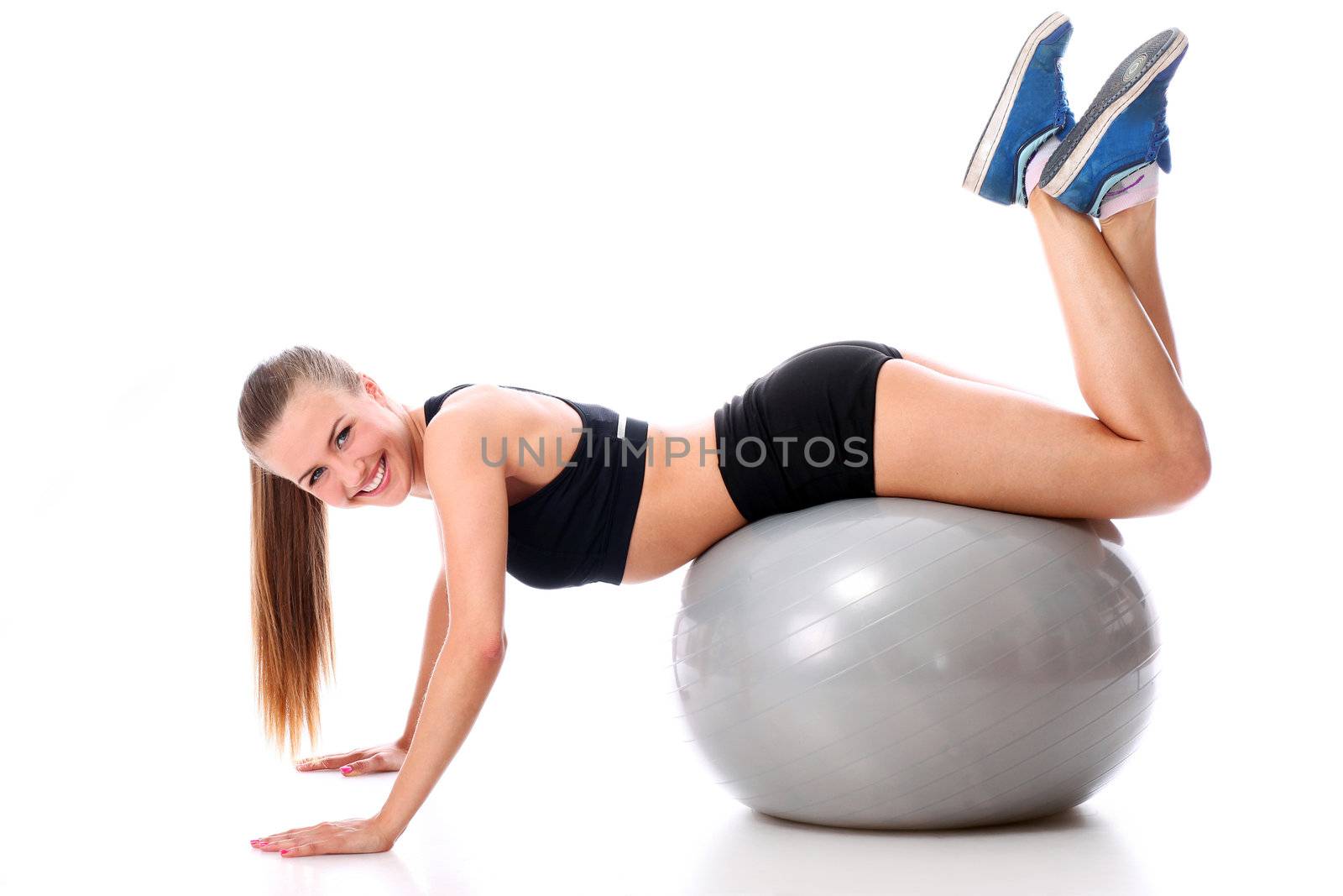 Beautiful and smiling woman doing abs exercises with fitness ball over white background