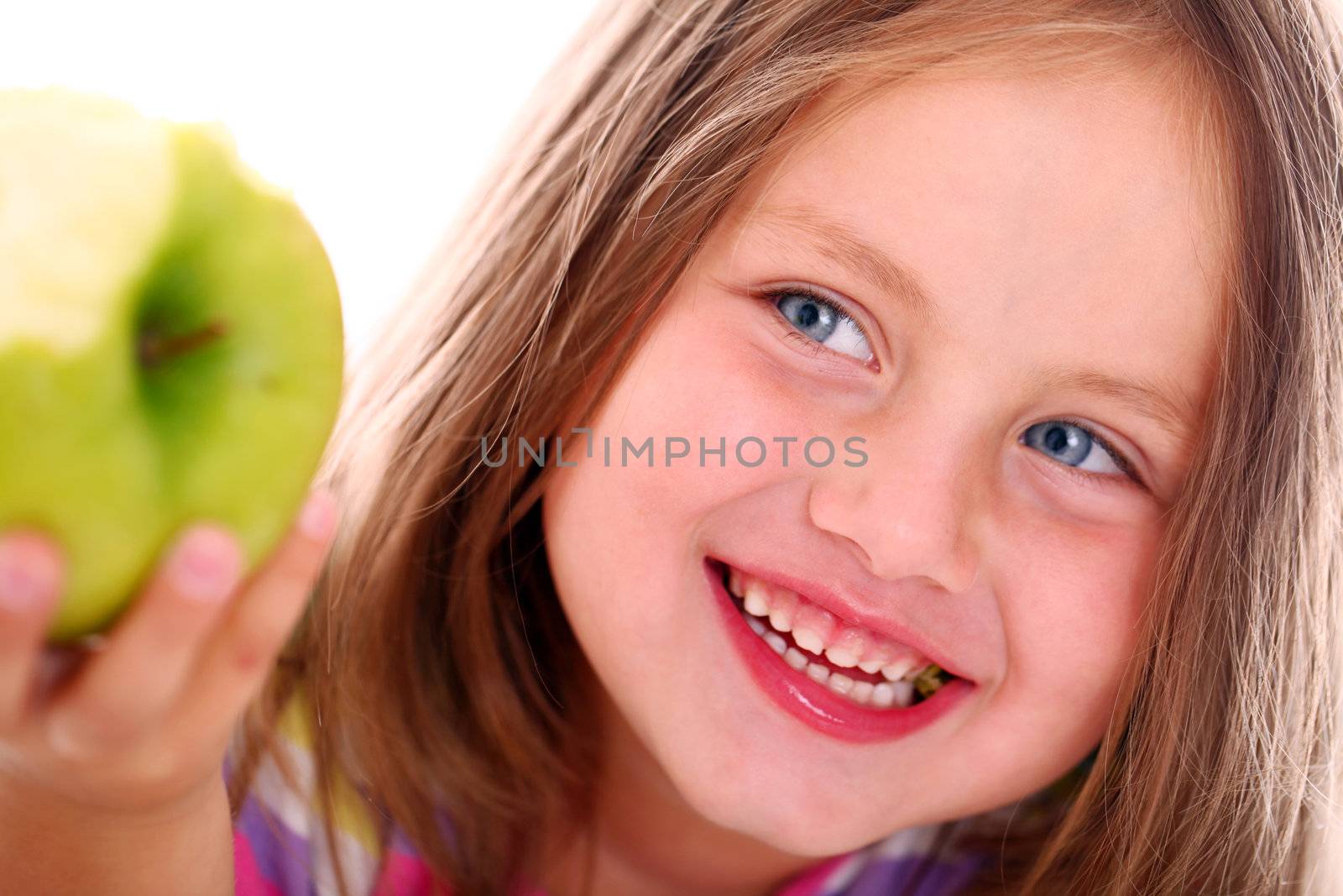 Portrait of little girl eating green apple