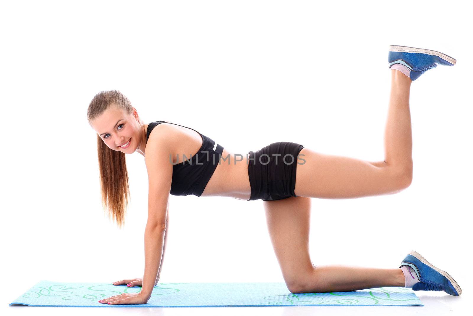 Happy girl doing fitness exercises on a mat by rufatjumali