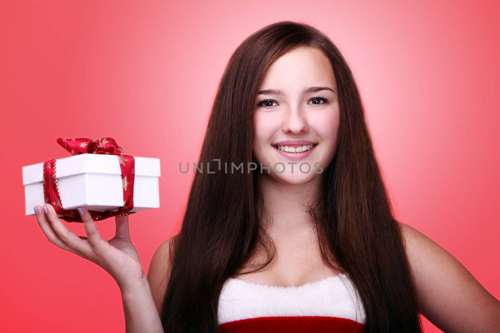 Portrait of young and beautiful christmas girl in red with gift