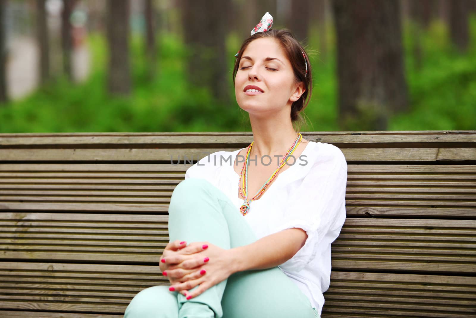 A beautiful woman is sitting on a park bench by rufatjumali