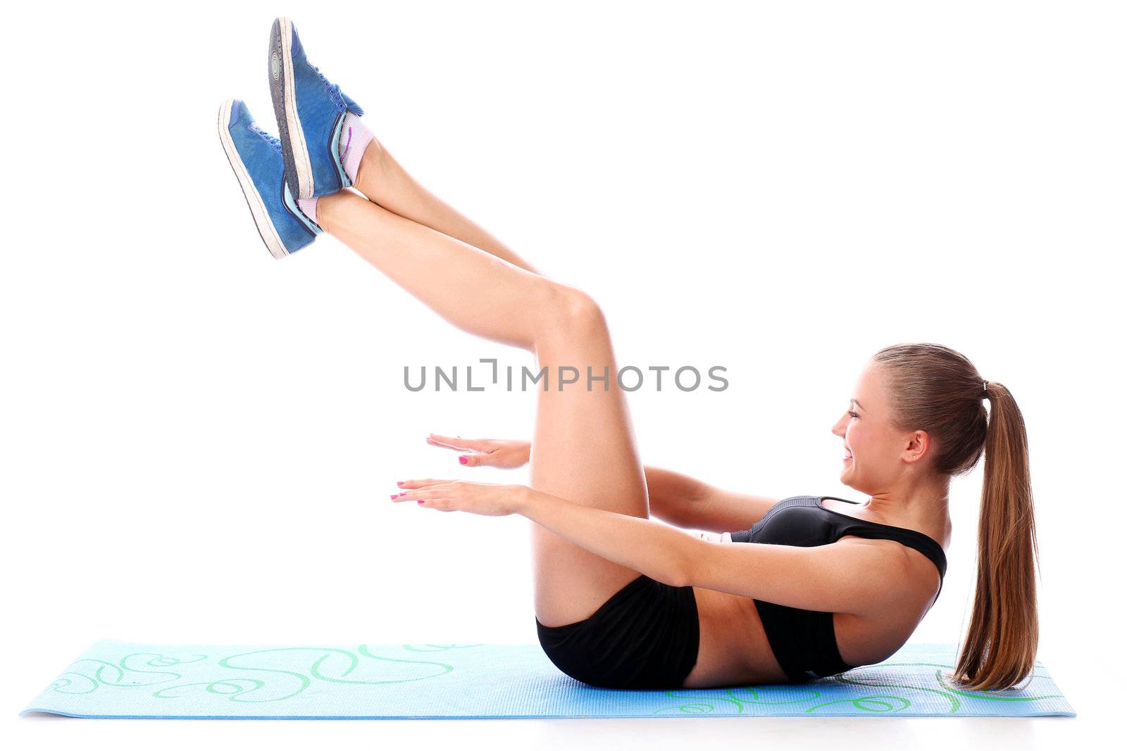Happy girl doing fitness exercises on a mat over white background
