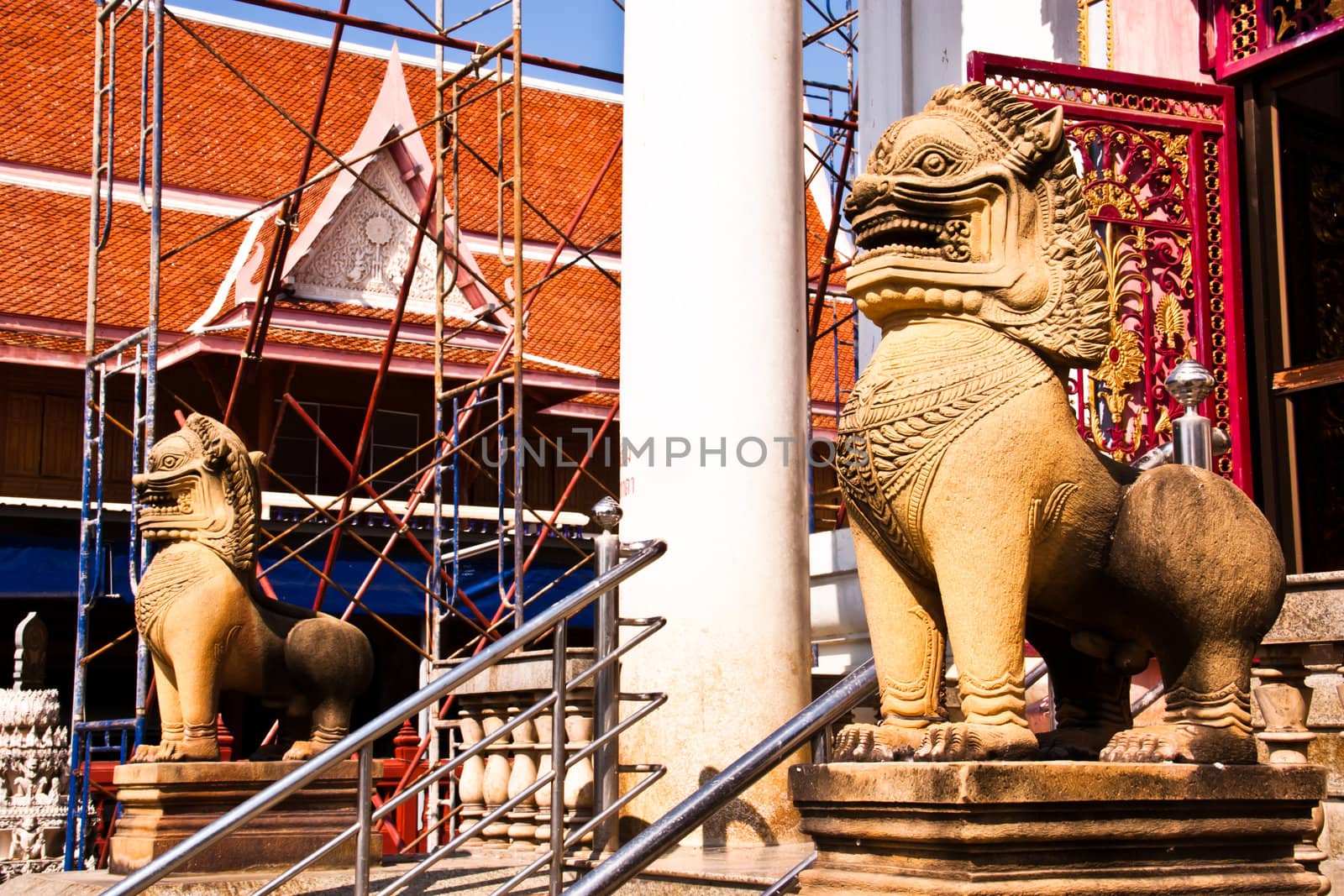 The lion statues made ​​of stone. Stand in front of a temple in Thailand at Phetchaburi province.