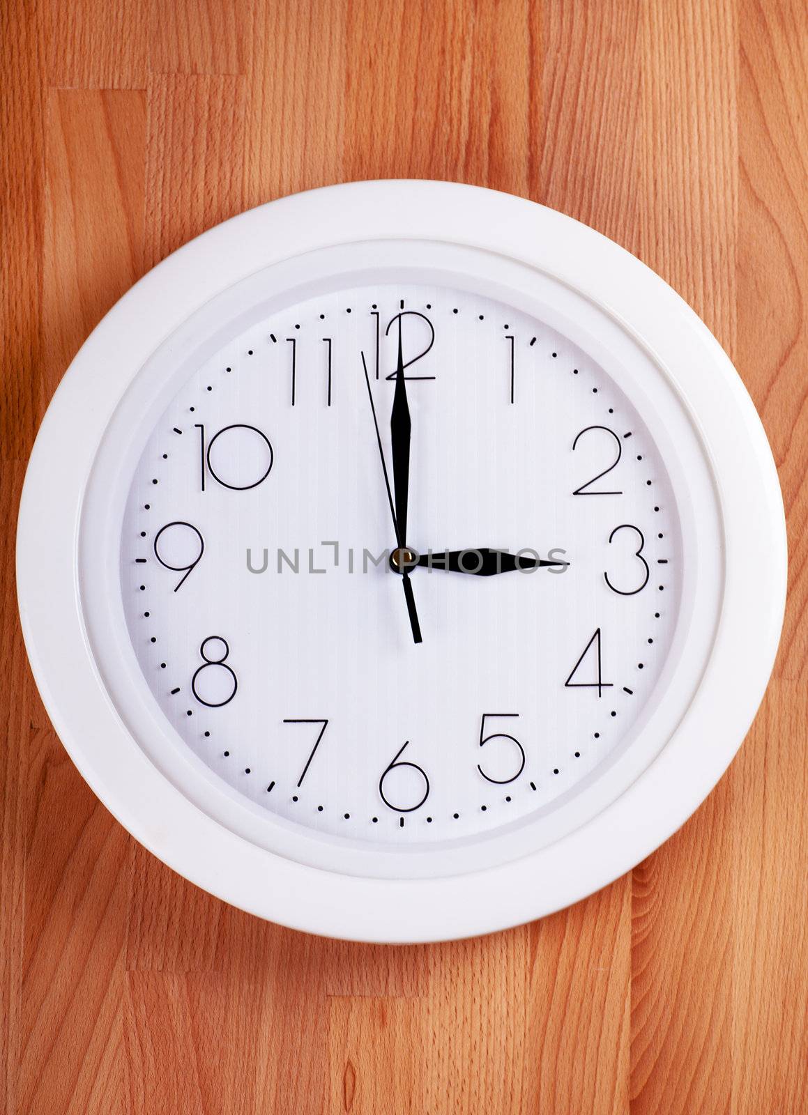 White clock hanging on a wooden wall