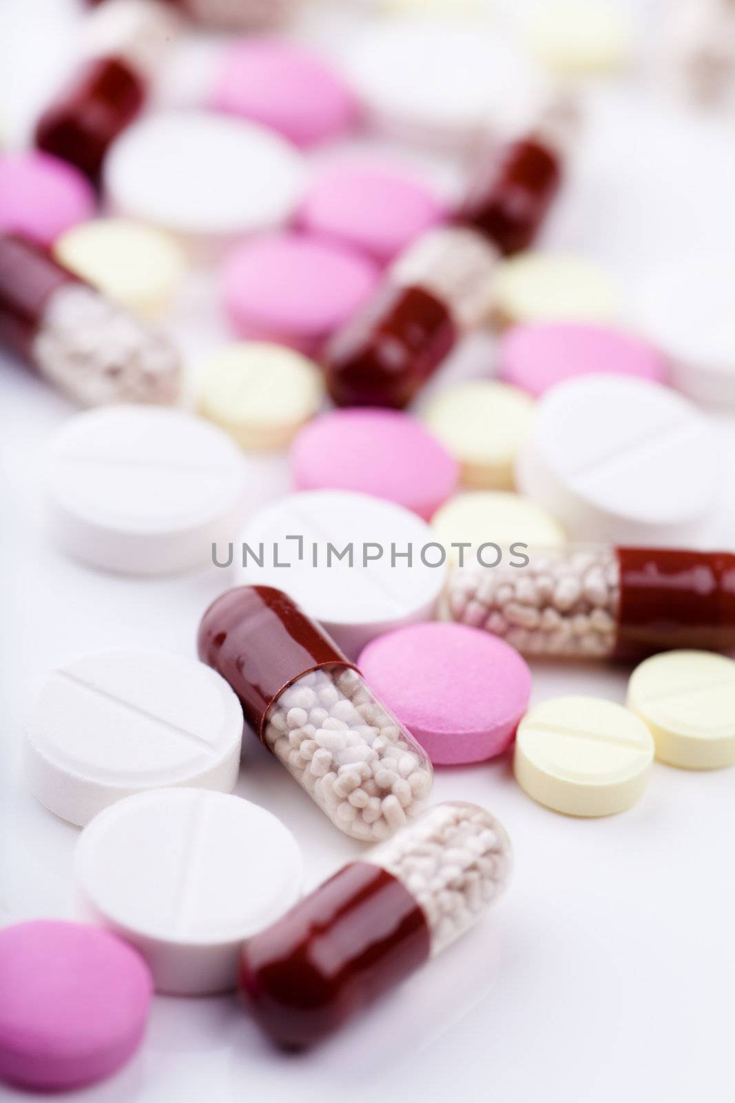 Macro view of heap of pills and capsules over white background