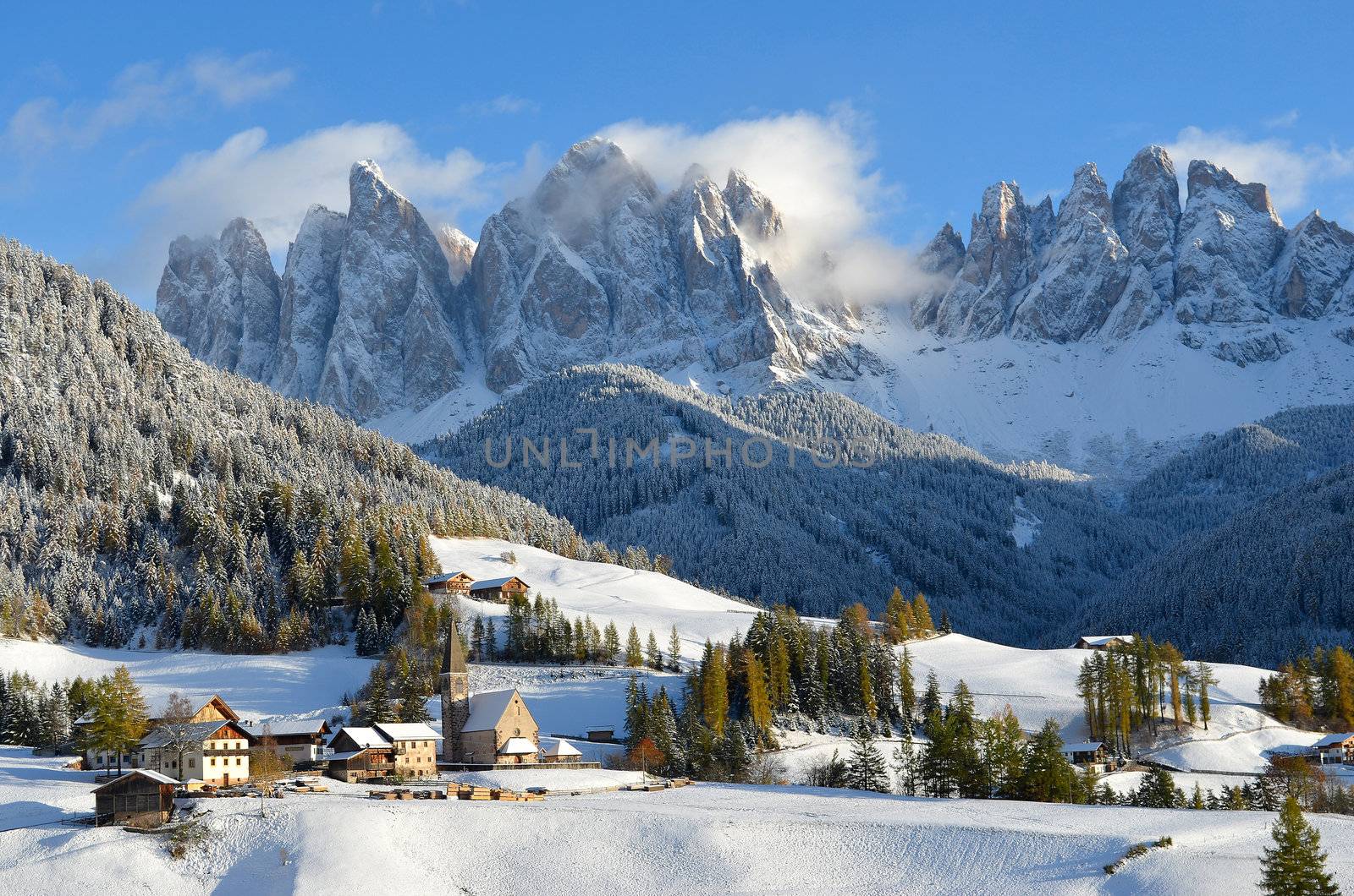 St. Magdalena or Santa Maddalena with its characteristic church in front of the Geisler or Odle dolomites mountain peaks in the Val di Funes (Villnosstal) in Italy in winter.