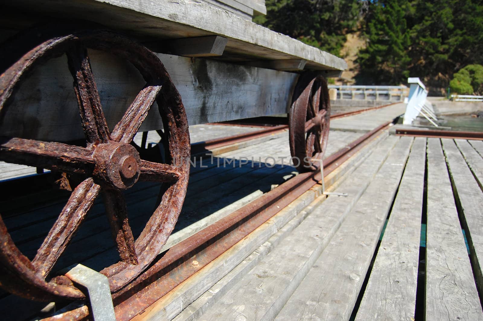 Metal wheels of old wagon on pier, Banks Peninsula, New Zealand