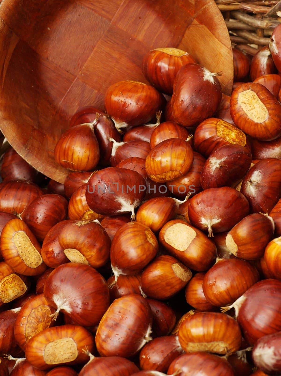 Wooden bowl scooping up chestnuts in a basket