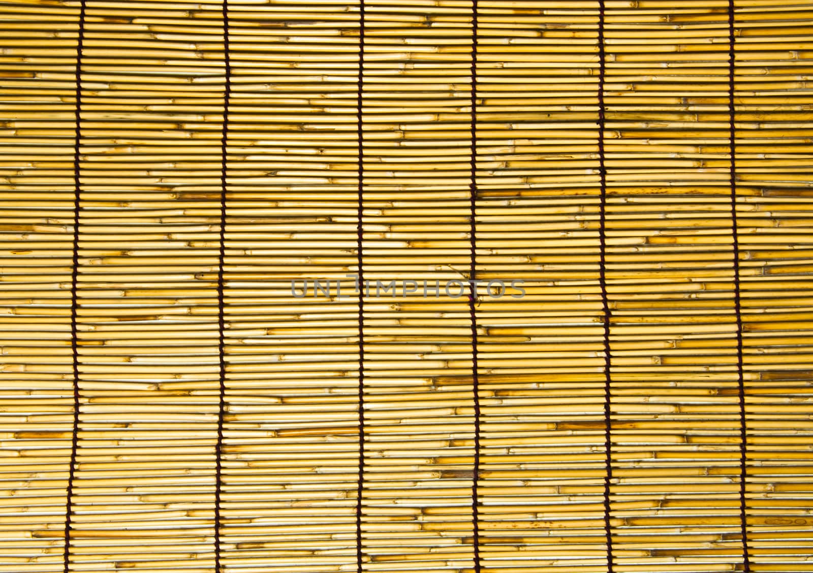 This is a wall of bamboo are woven together in a large sheet.