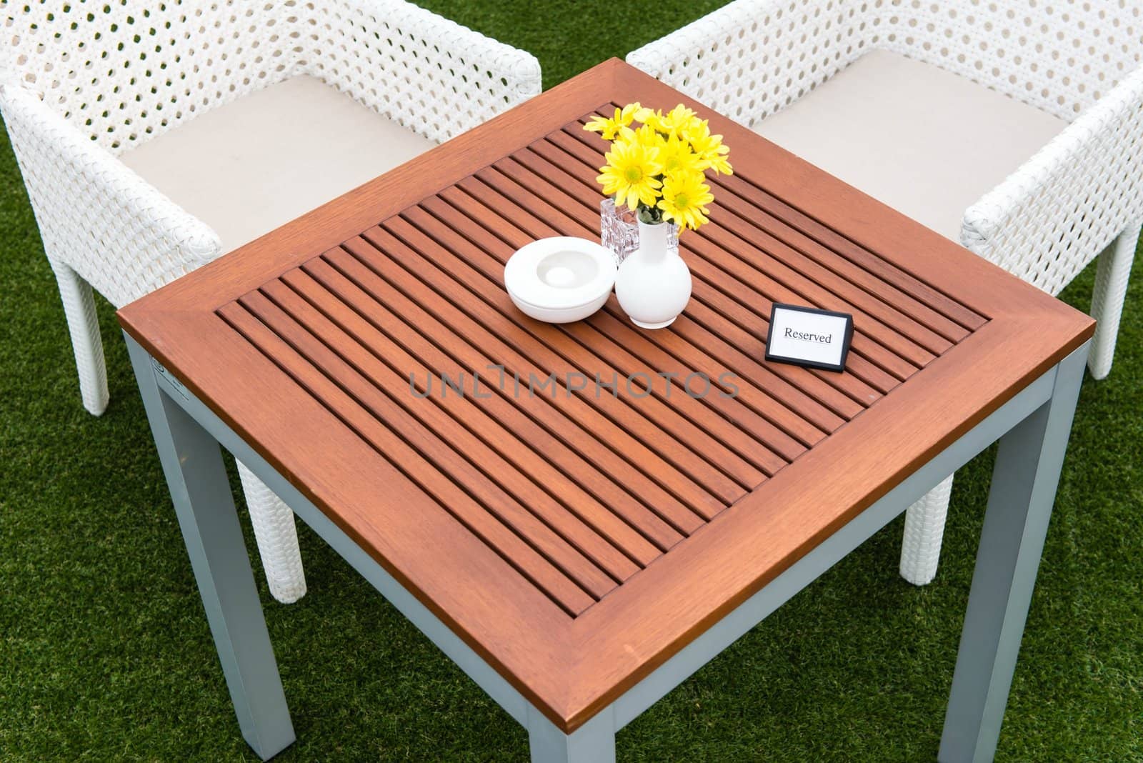 Tropical wooden dinning table on green grass by sasilsolutions