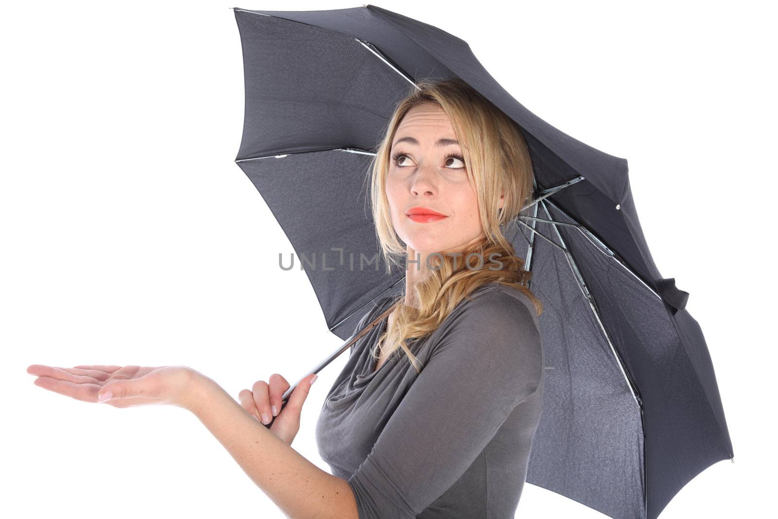 Blonde woman holding umbrella looking up checking for water on white background