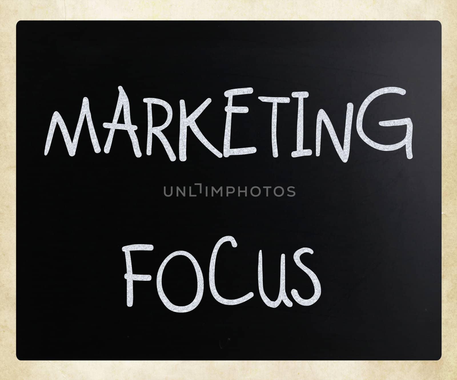 "Marketing focus" handwritten with white chalk on a blackboard.