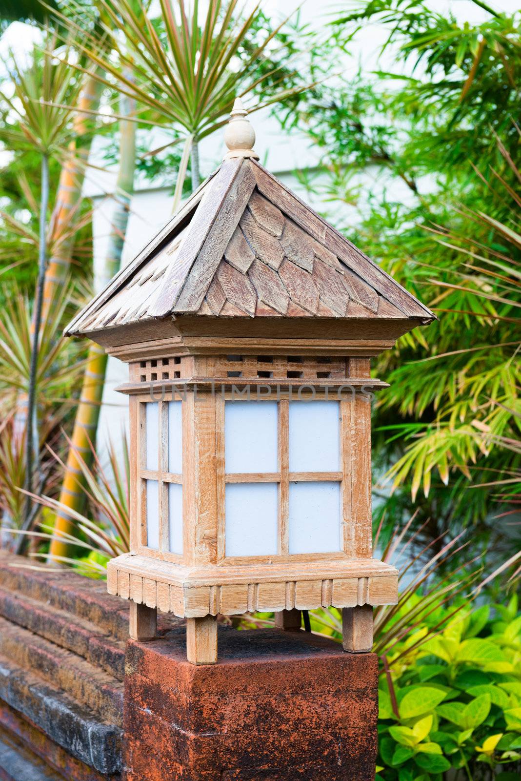 Balinese lanterns in the tropical garden on brick wall