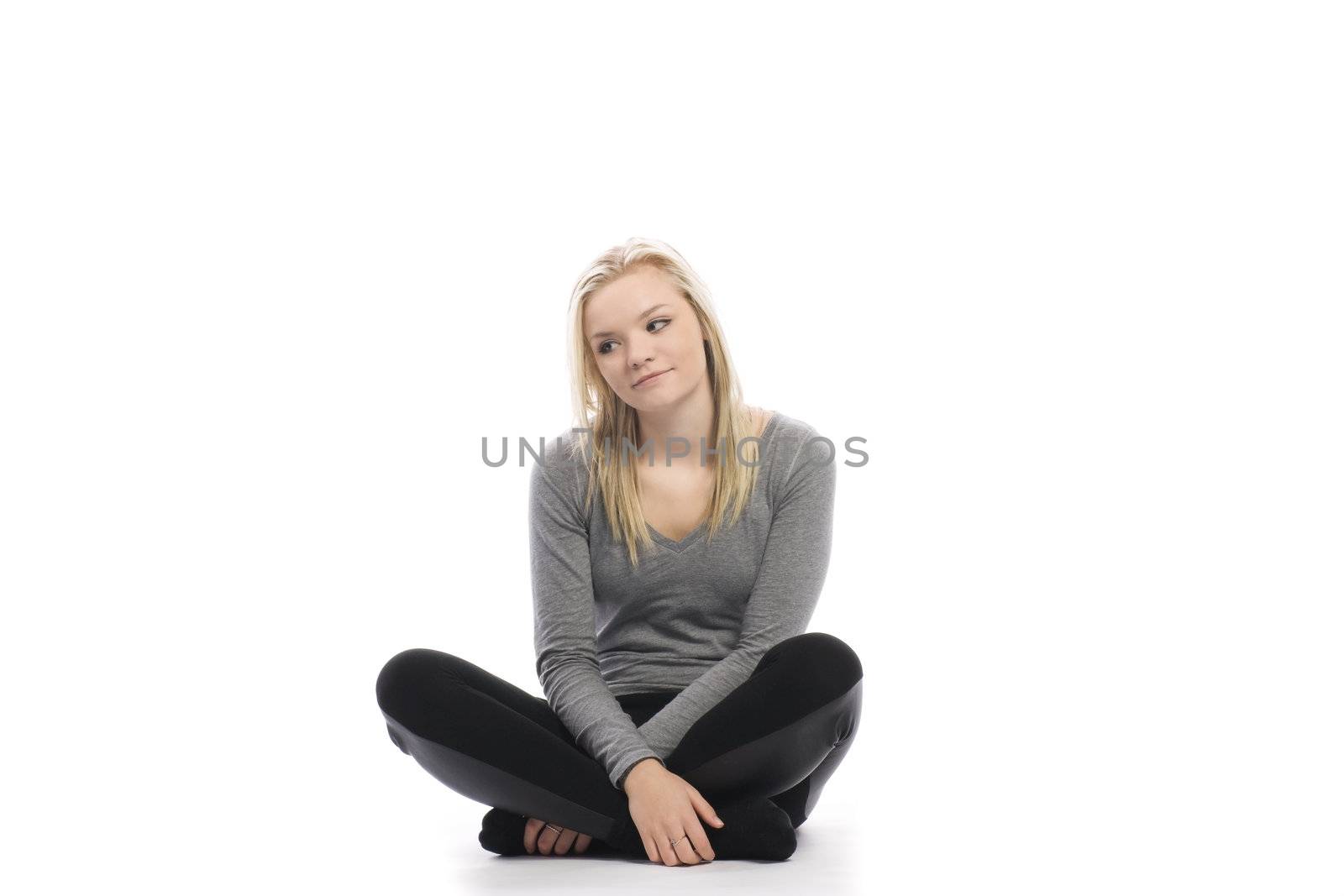 beautiful teenage girl sitting cross legged on white