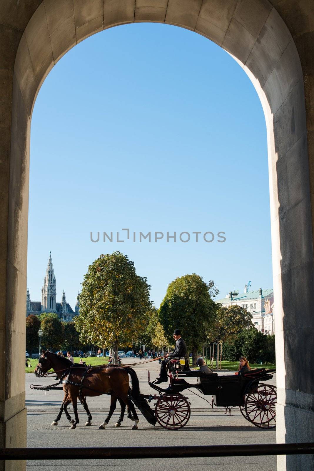 VIENNA - OCTOBER 3: Traditional horses and carriage (also called Fiaker) passing the famous Hofburg on October 3, 2012 in Vienna, Austria. The Fiaker rides are a traditional tourist attraction -200 carriages are available each day in this city.