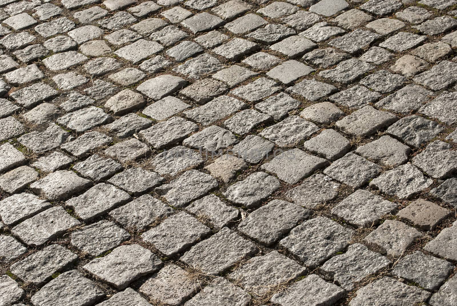 Granite gray town pavement close-up as background diagonal view