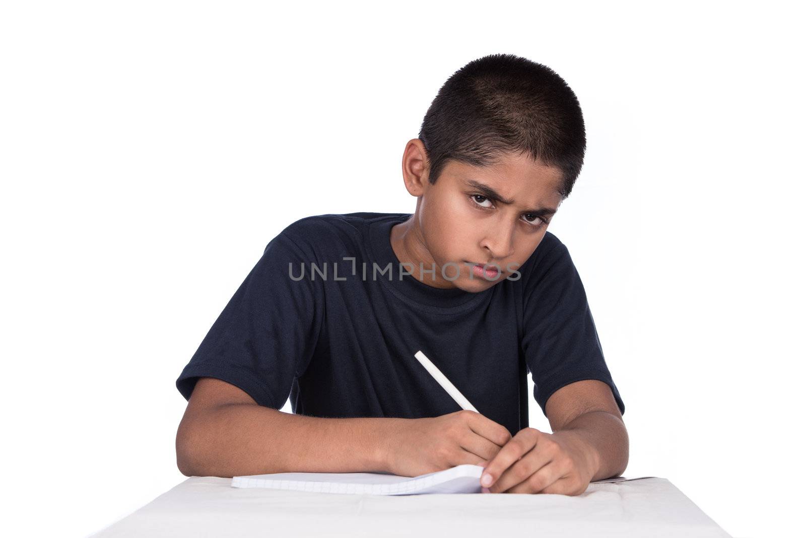An handsome Indian kid doing his homework diligently, with ample copyspace