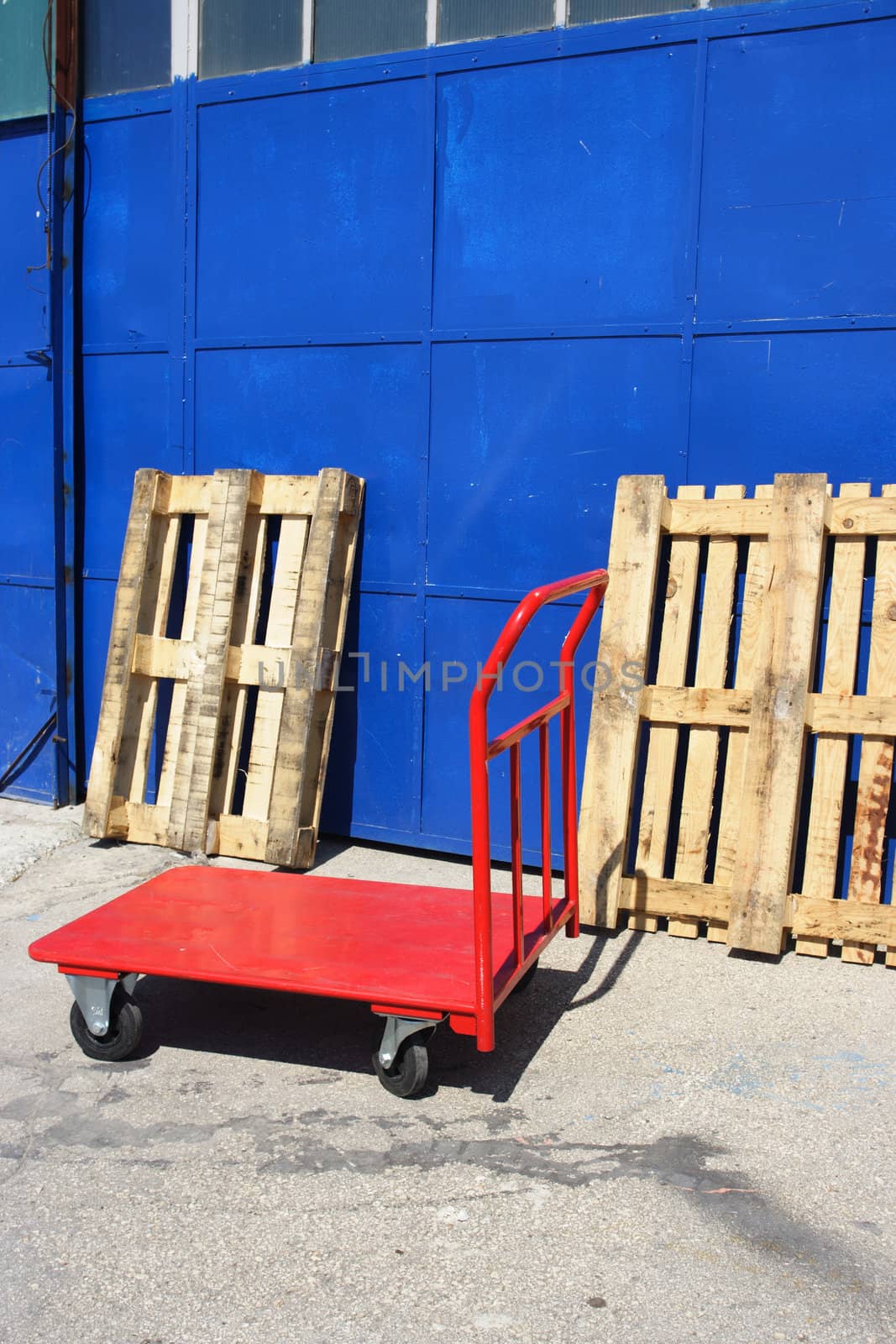 red hand truck in front of warehouse 