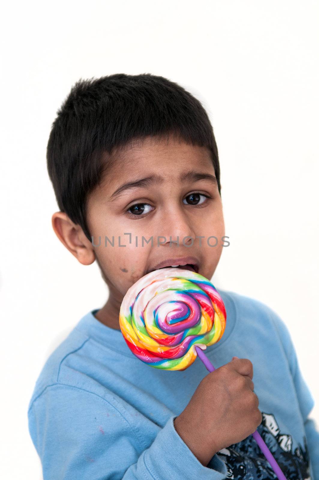 An handsome Indian kid having fun with his candy