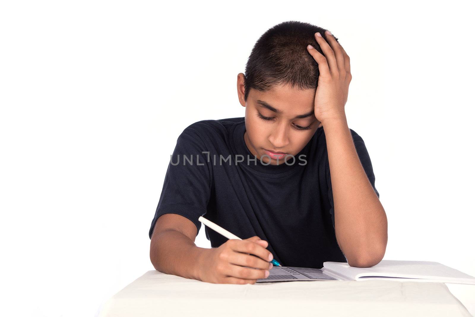 An handsome Indian kid doing his homework diligently, with ample copyspace