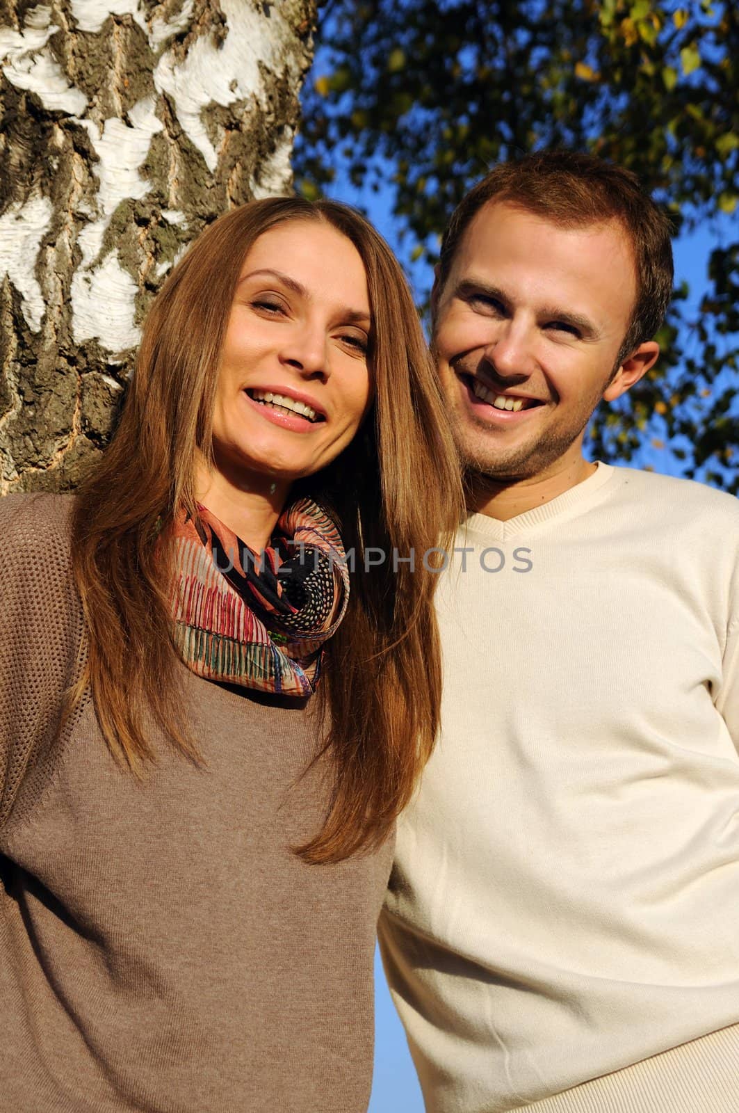 Young couple under a tree in autumn